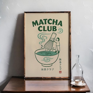 Może przedstawiać: Oprawiony wydruk artystyczny Matcha Club. Ilustracja przedstawia osobę ubijającą matchę w misce, z unoszącą się parą. Słowa "Matcha Club" są u góry w kolorze zielonym, z japońskim tekstem poniżej i czerwoną pieczęcią.