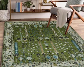 May include: A green area rug with a floral pattern in shades of blue, green, and white. The rug has a border with a geometric design.