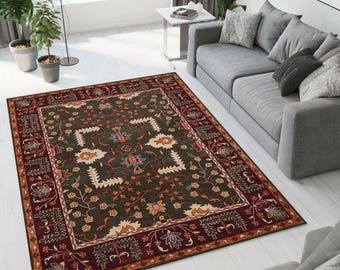 Könnte beinhalten: Ein rechteckiger Teppich mit dunkelgrünem Zentrum und burgunderrotem Rand. Der Teppich zeigt florale und geometrische Muster in Orange, Creme und Blau. Er liegt auf einem weißen Holzboden in einem Wohnzimmer.