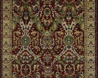 May include: A red, green, and cream colored rug with a traditional Persian design. The rug has a detailed border with intricate patterns.
