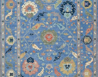 May include: A blue rug with a traditional Persian design. The rug features intricate floral patterns and geometric shapes in shades of blue, red, green, and beige.