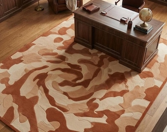 May include: A rectangular area rug featuring a swirling, abstract pattern in shades of terracotta, tan, and cream. The rug has a textured, carved pile surface with organic, flowing shapes that create a sense of movement across the floor.