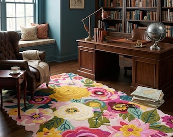 May include: A colorful floral rug with a pink background and large, vibrant flowers in shades of yellow, pink, and white. The rug is placed in a room with a wooden desk, bookshelves, and a leather armchair, creating a cozy and inviting atmosphere.