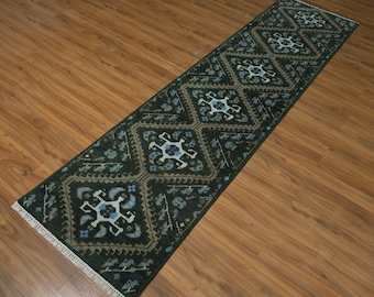 May include: A dark green runner rug with a repeating geometric pattern in shades of blue, tan, and white. The rug has a rectangular shape and is displayed on a wooden floor. The rug's design features diamond shapes and floral motifs.