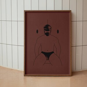 May include: A framed art print featuring a minimalist line drawing of a person wearing a mask and underwear. The artwork is set against a maroon background and framed in a wooden frame. The style is modern and abstract.