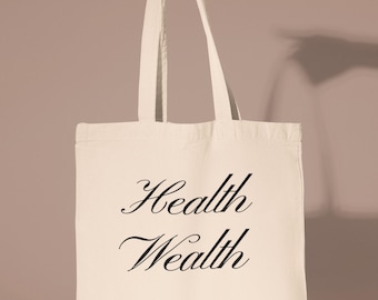 May include: A white canvas tote bag with black text that reads "Health Wealth PILATES".