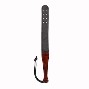May include: A black leather paddle with a wooden handle and a black cord. The paddle has multiple holes in the leather.