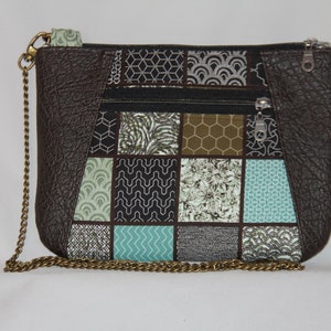 May include: A brown leather crossbody bag with a chain strap. The front of the bag is made of a patchwork of different fabrics with geometric patterns in shades of green, brown, and white.