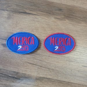 May include: Two oval-shaped embroidered patches featuring a blue background with red text that reads 'MERICA and the number 250 in white. One patch has a blue border, while the other patch features a red border around the oval edge.