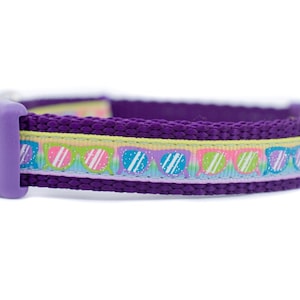 May include: Purple dog collar with a colorful pattern of sunglasses.