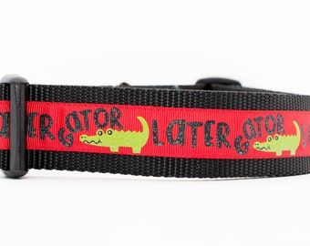 May include: Black and red dog collar with a green alligator graphic and the text "Later Gator" repeated on the red stripe.
