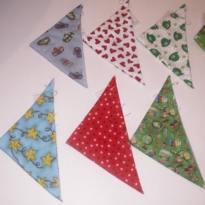May include: Assortment of triangular bandanas in various patterns. Designs include red hearts on white, green shamrocks, blue with yellow stars, red with white stars, and a green print with books and globes. Each bandana has a small tag attached.