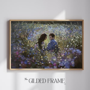 May include: A couple embraces in a field of wildflowers. The woman has long brown hair and is wearing a white dress. The man has short brown hair and is wearing a blue shirt. The flowers are a mix of purple, blue, and white.