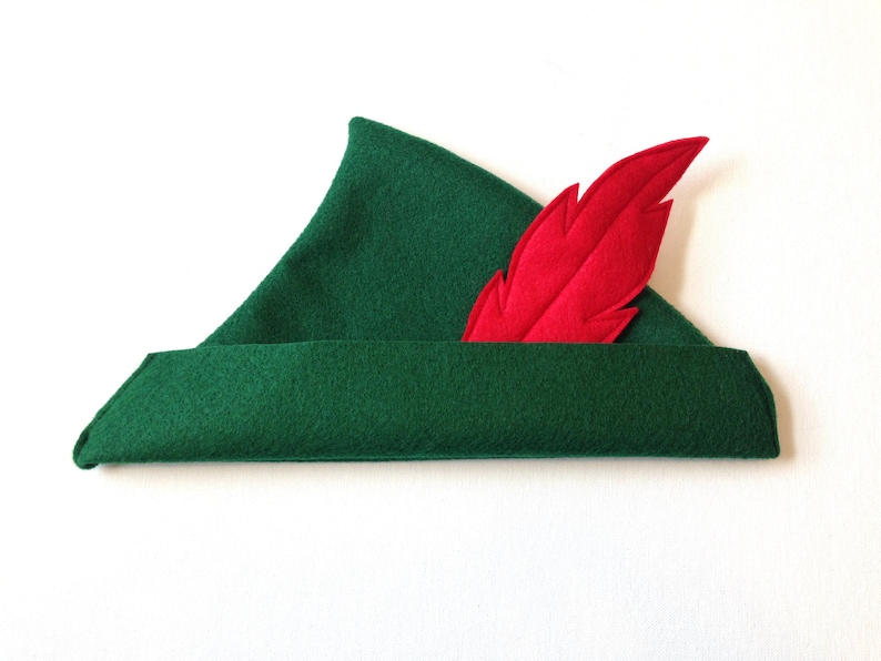 May include: A green felt hat with a red felt feather attached to the side.