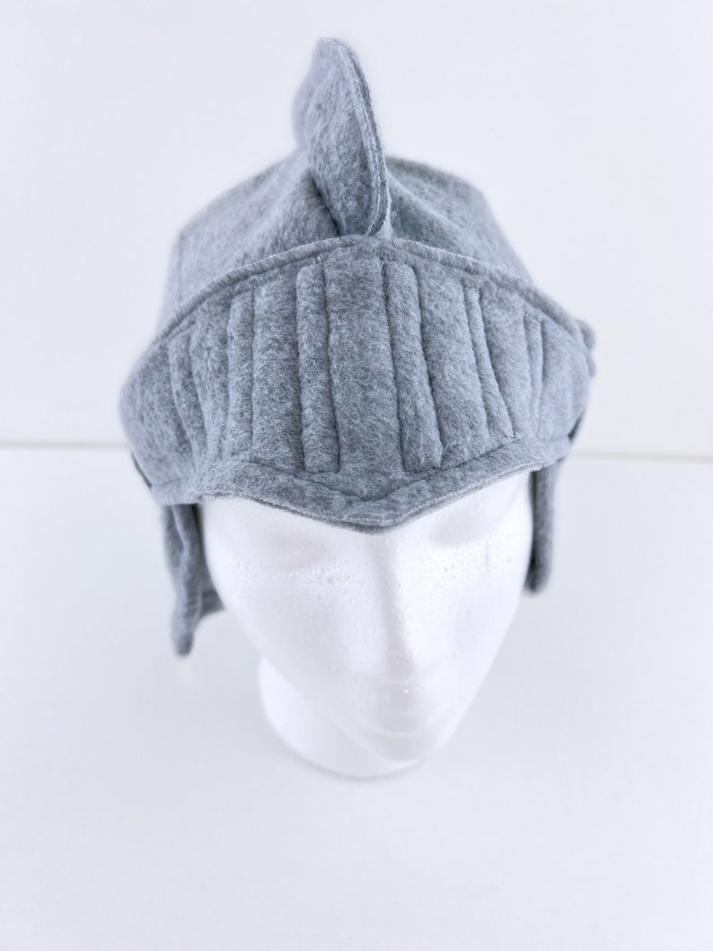 May include: Gray felt knight helmet hat with a pointed top and a visor. The hat is on a white mannequin head.
