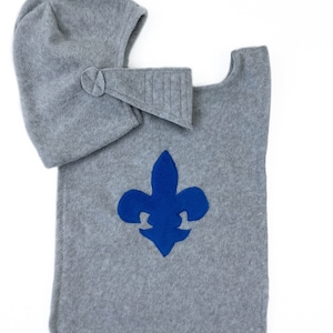 May include: Gray fleece knight costume with a blue fleur-de-lis emblem and a matching hat.