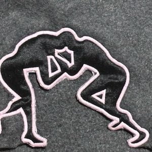 May include: A black and white silhouette of two figures wrestling, outlined in pink. The figures are in a dynamic pose, with one figure on top of the other.