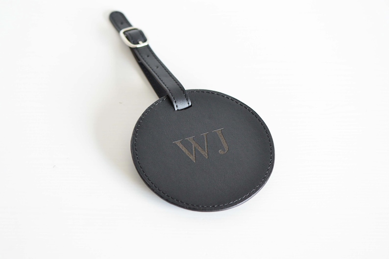 May include: Black leather luggage tag with a silver buckle and the initials "WJ" embossed in the center.