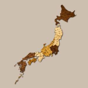 Pode incluir: Um mapa de madeira do Japão, mostrando as províncias do país em tons de castanho. O mapa é detalhado com nomes de lugares e está sobre um fundo neutro. Um item decorativo.