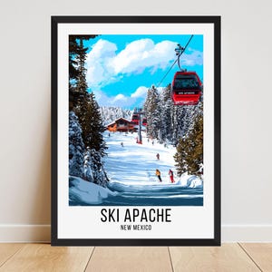 Puede incluir: Una impresión artística enmarcada de una escena de esquí nevada. Un teleférico rojo está suspendido en el aire. Las palabras "SKI APACHE NEW MEXICO" están impresas en la parte inferior. El cielo es azul con nubes blancas.