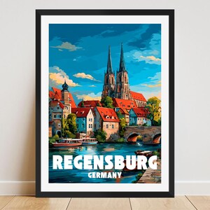 Könnte beinhalten: Ein gerahmter Kunstdruck von Regensburg, Deutschland, mit einer farbenfrohen Illustration der Architektur der Stadt. Das Kunstwerk zeigt eine Flussszene mit Gebäuden, Brücken und einer Kathedrale unter blauem Himmel. Die Wörter "Regensburg" und "Germany" sind unten aufgedruckt.