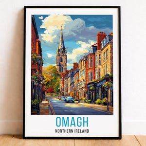 Puede incluir: Impresión artística enmarcada de Omagh, Irlanda del Norte. La imagen representa una colorida escena callejera con edificios y una torre de iglesia bajo un cielo azul. El texto "OMAGH" y "NORTHERN IRELAND" están en la parte inferior.