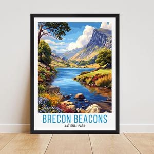 Könnte beinhalten: Gerahmter Kunstdruck mit einer malerischen Landschaft des Brecon Beacons Nationalparks. Das Kunstwerk zeigt einen ruhigen See, umgeben von Bergen, üppigem Grün und einem strahlend blauen Himmel. Der Text "BRECON BEACONS NATIONAL PARK" ist unten zu sehen.