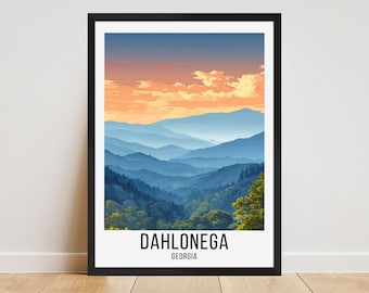 May include: A framed art print featuring a scenic mountain landscape. The artwork depicts layers of blue mountains under a vibrant orange and blue sky. The text "DAHLONEGA GEORGIA" is printed at the bottom in a clean, sans-serif font.