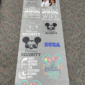 May include: A long, translucent sheet of heat transfer vinyl featuring various printed designs, including Mickey Mouse ears, text such as Princess Security, Birthday Squad, Mother of the Bride, and inspirational quotes, alongside small photographic portraits.