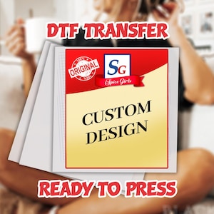 May include: A stack of white DTF transfer sheets with a custom design. The design features a red and yellow background with the text "CUSTOM DESIGN" and the Spice Girls logo. The text "DTF TRANSFER" and "READY TO PRESS" are also visible.