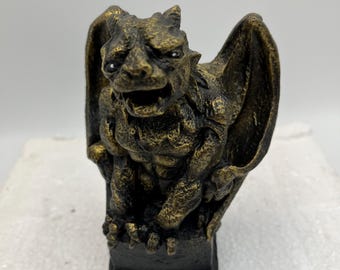 Estatua de gárgola de piedra fundida, color negro/dorado.