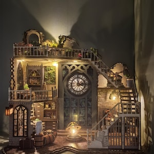 Könnte beinhalten: Ein detailliertes Miniatur-Puppenhaus aus Holz mit mehreren Ebenen, das einen Uhrturm, Balkone und Treppenhäuser aufweist. Das Puppenhaus ist mit warmer Beleuchtung versehen, die komplizierte architektonische Details und dekorative Elemente hervorhebt.