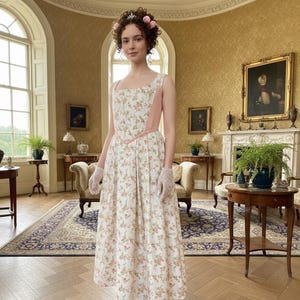 Könnte beinhalten: Ein ärmelloses, bodenlanges Kleid aus weißem Stoff mit kleinem rosa-grünem Blumenmuster, quadratischem Ausschnitt und einfarbigen rosa Seitenteilen. Das Kleid wird mit weißen Spitzenhandschuhen und einem kleinen Haarschmuck kombiniert.