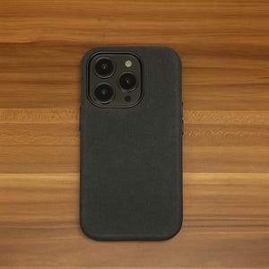 May include: A black phone case with a textured surface and a camera lens with four black circles.