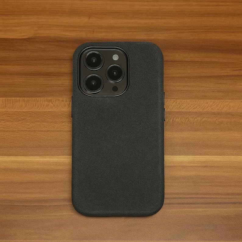 May include: A black phone case with a textured surface and a camera lens with four black circles.