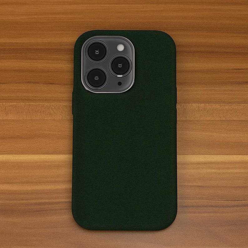 May include: A dark green phone case with a camera lens cutout. The case is made of a soft, textured material.