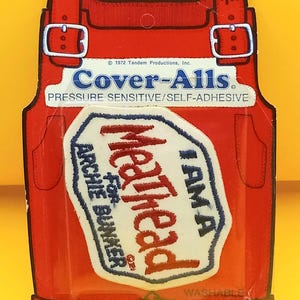 May include: Vintage red Cover-Alls patch featuring a white and blue patch with the text "Meathead for Archie Bunker". The patch is in the shape of overalls and includes the text "Pressure Sensitive/Self-Adhesive".