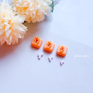 May include: Four orange plastic cookie cutters shaped like cacti, with three white plastic cacti cutouts on a white surface. The text '@lulicutters' is in the bottom right corner of the image.