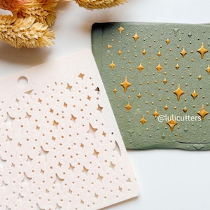 Può includere: Uno stencil rosa chiaro con ritagli a forma di stella accanto a un oggetto rettangolare verde con decorazioni a stella dorata. L'oggetto verde ha una superficie strutturata. Il testo "@lulicutters" è visibile sull'oggetto verde.