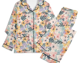 May include: A two-piece floral pajama set. The top has a notched collar and button-down front, with a matching pair of trousers. The floral pattern includes yellow, pink, and blue hues on a cream backdrop. Black piping trims the edges.