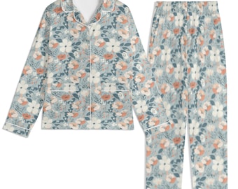 May include: A floral patterned pyjama set in blue, white, and peach. The long-sleeved top has a collared neckline, front pockets, and white trim. The matching trousers have an elasticated waistband and a similar floral design. The set is designed for comfort.