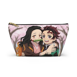 May include: A zippered cosmetic bag featuring a colorful anime illustration of two characters hugging. The bag has a pink background with cherry blossom trees and a gold zipper.