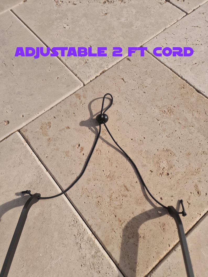 May include: A black adjustable cord with a sliding bead for adjustment. The cord is approximately 2 feet long. The text "ADJUSTABLE 2 FT CORD" is displayed in purple.