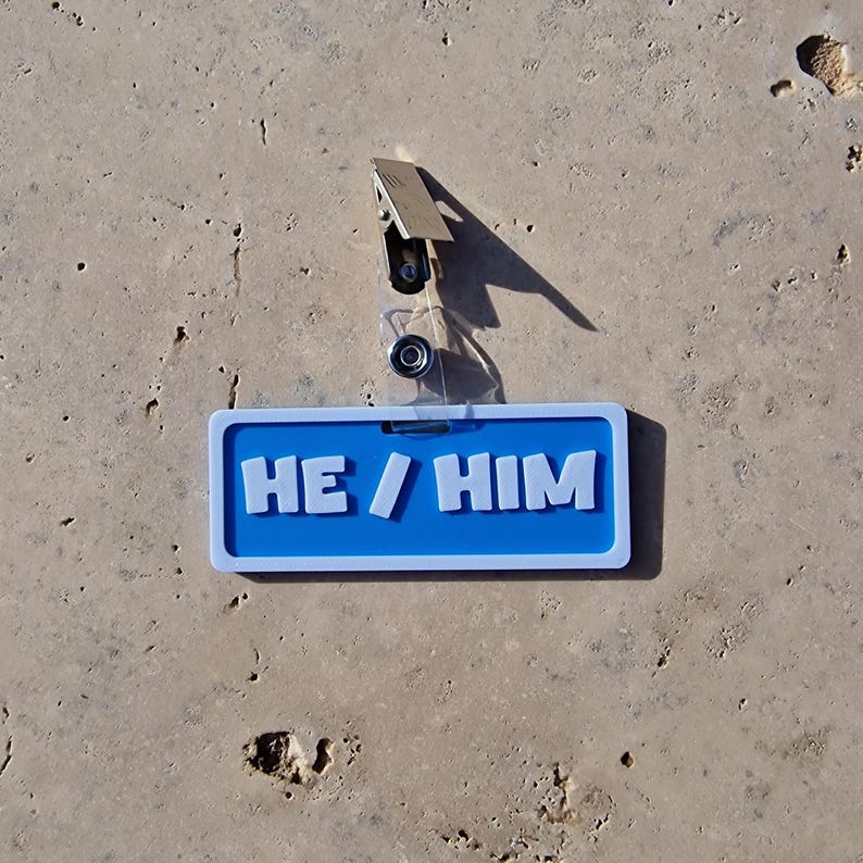 Badge showing he/him on a tile background.