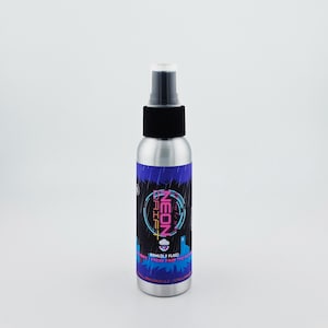May include: A silver spray bottle with a black cap and a label featuring the text "NEON DRIFT" in pink and blue. The label also includes the text "80ml (2.7 FL OZ)" and a graphic of a cityscape.