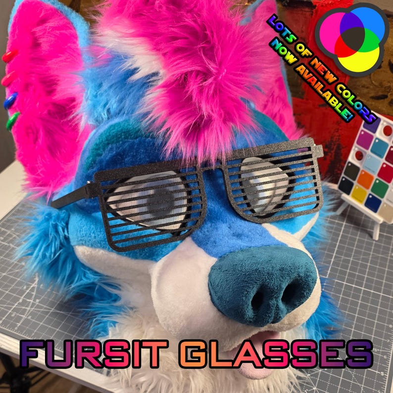 May include: A blue, white, and pink fursuit head with black, slatted glasses. The text "Fursit Glasses" is at the bottom. The image also includes a color palette and the text "Lots of new colors now available!"