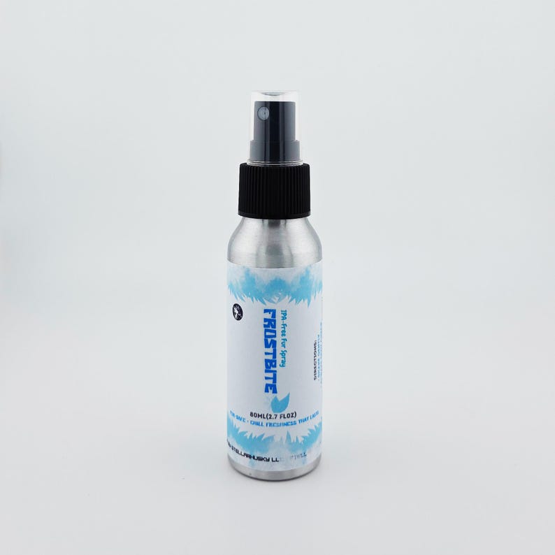 May include: A silver spray bottle with a black cap and nozzle. The label features the word "FROSTBITE" in blue, along with a blue wave design. The bottle contains 60ml (2.7 fl oz) of product.