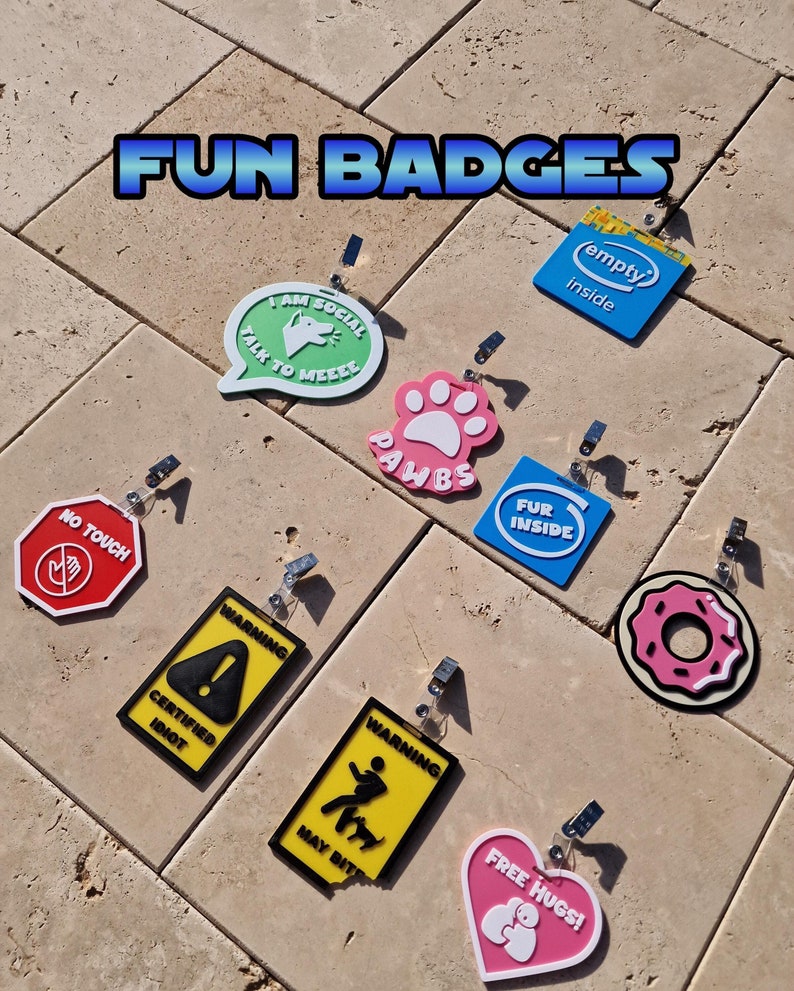 Badges representing playful statements,such as pawbs, social,may bite and free hugs, and more. they all have lanyard clips.