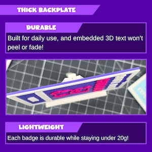 May include: A rectangular badge with a white frame, blue background, and pink text. The text reads "Durable" and "Lightweight". The badge is described as having a thick backplate and embedded 3D text that won't peel or fade. Each badge weighs under 20 grams.