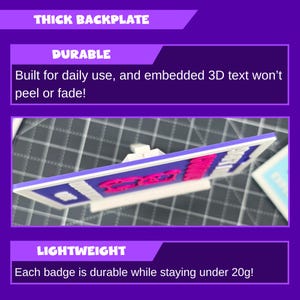 May include: A rectangular badge with a white frame, blue background, and pink text. The text reads "Durable" and "Lightweight". The badge is described as having a thick backplate and embedded 3D text that won't peel or fade. Each badge weighs under 20 grams.